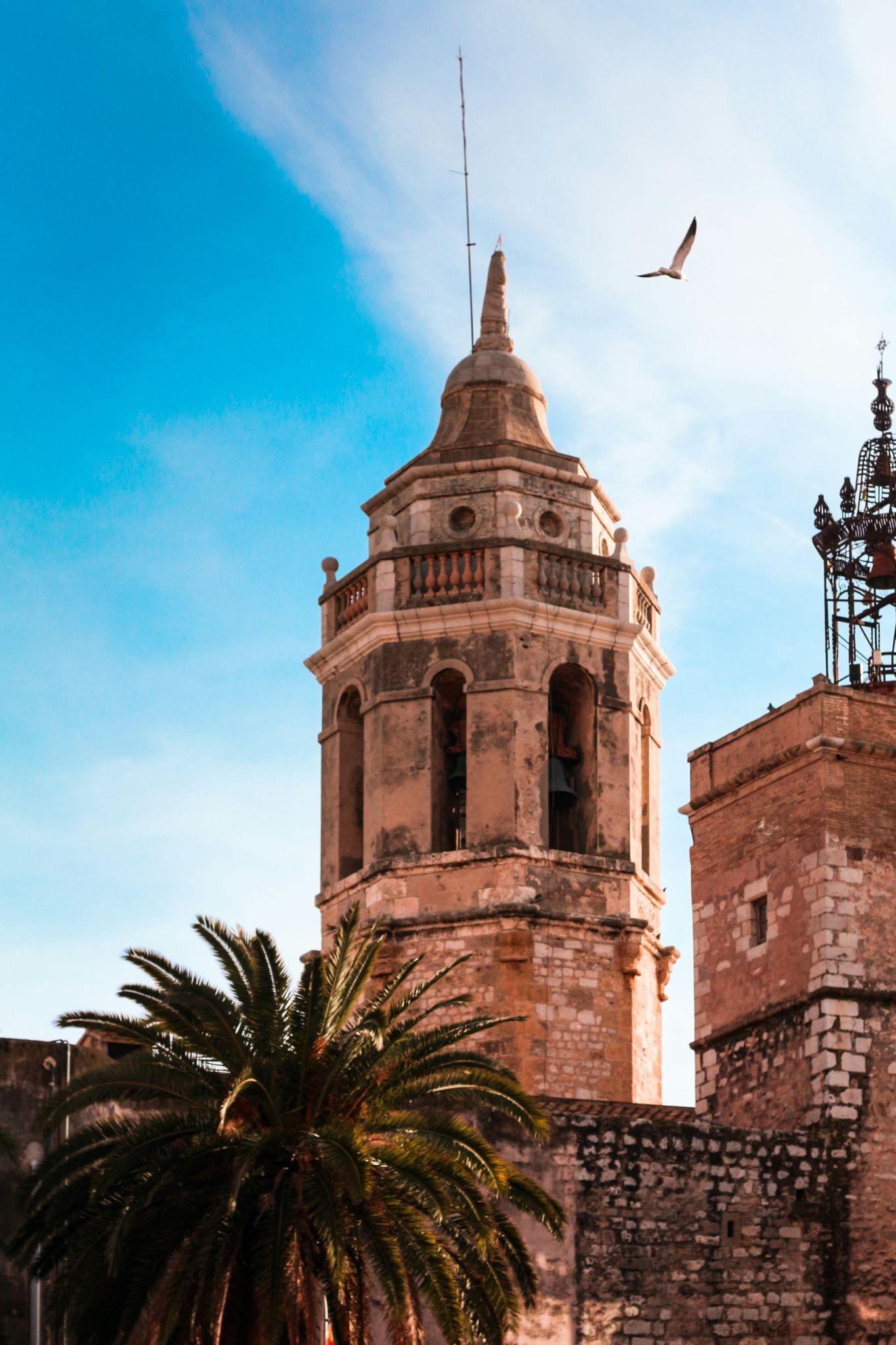 Sitges old town — Sant Bartomeu i Santa Tecla church tower with a palm tree